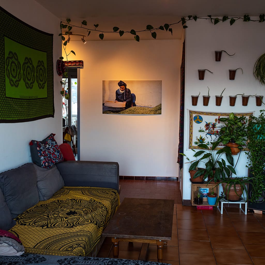 Fine art print of a man sieving cannabis in Afghanistan displayed in a living room.